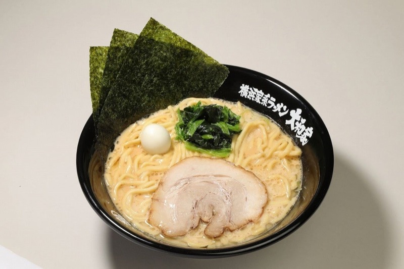 横浜家系ラーメン大和家の家系ラーメン。クリーミーで濃厚な豚骨スープに加水率を抑えた中太ストレート麺、チャーシュー・ほうれん草・海苔・味玉がトッピングされ、店名入りの黒い丼に盛り付けられた一杯
