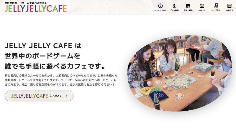 JELLY JELLY CAFE公式サイトのトップ。左に世界中のボードゲームを誰でも手軽に遊べるカフェですとの説明、右の楕円写真には棚にゲームが並ぶ店内で4人がテーブルを囲む様子