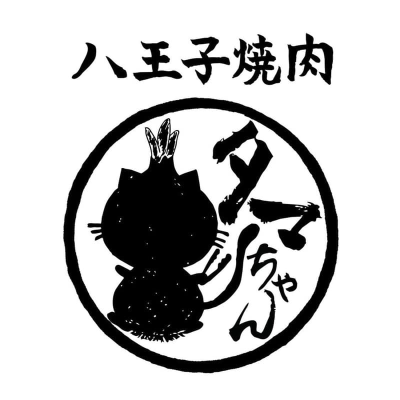 白地に黒い筆文字で八王子焼肉と書かれ、中央の丸枠に猫の後ろ姿のシルエットと縦書きのタマちゃんがあるロゴ