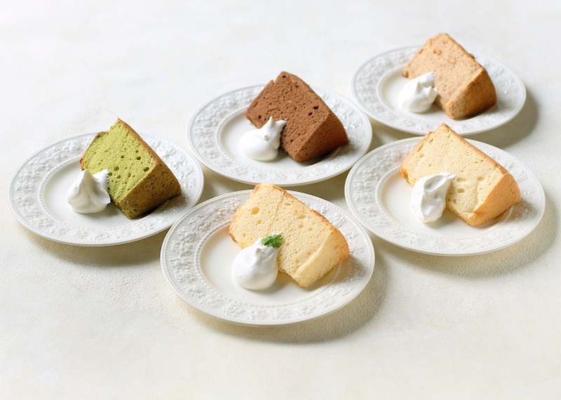 白い皿5枚に、抹茶、ココア、プレーンなど色の異なるシフォンケーキが1切れずつのり、それぞれ泡立てた生クリームが添えられている